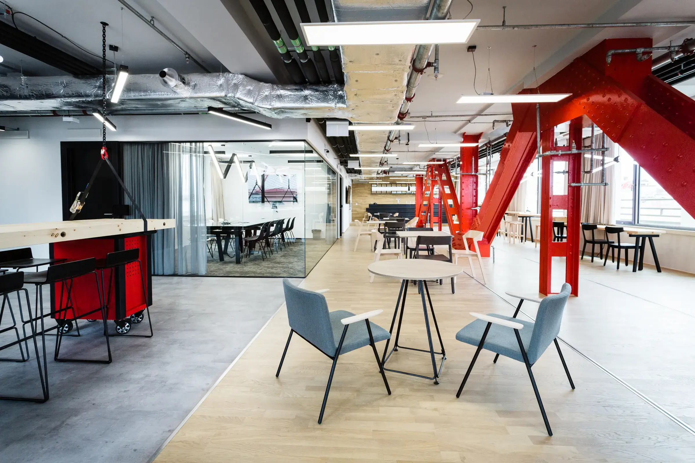 Coworkingové patro Zenwork s červenými nosníky a denním světlem
